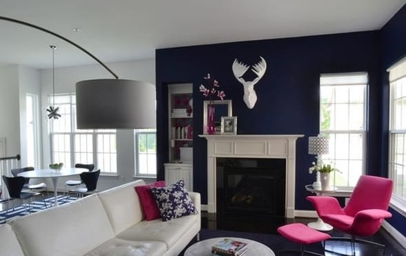 wohnzimmer farbgestaltung in weiß und blau-blaue wand mit weißem kamin und ledersofa weiß-polstermöbelstück sessel pink-weißer esstisch rund mit blauen hilzstühlen und teppich in blau weiß