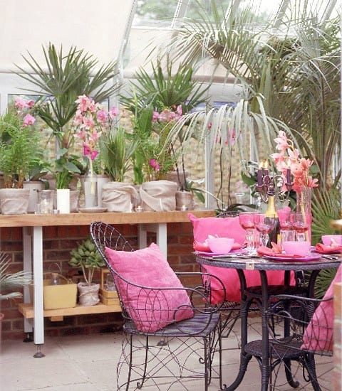 Palmengarten und schwarzen Gartenmöbel aus Stahl mit rosafarbigen Kissen