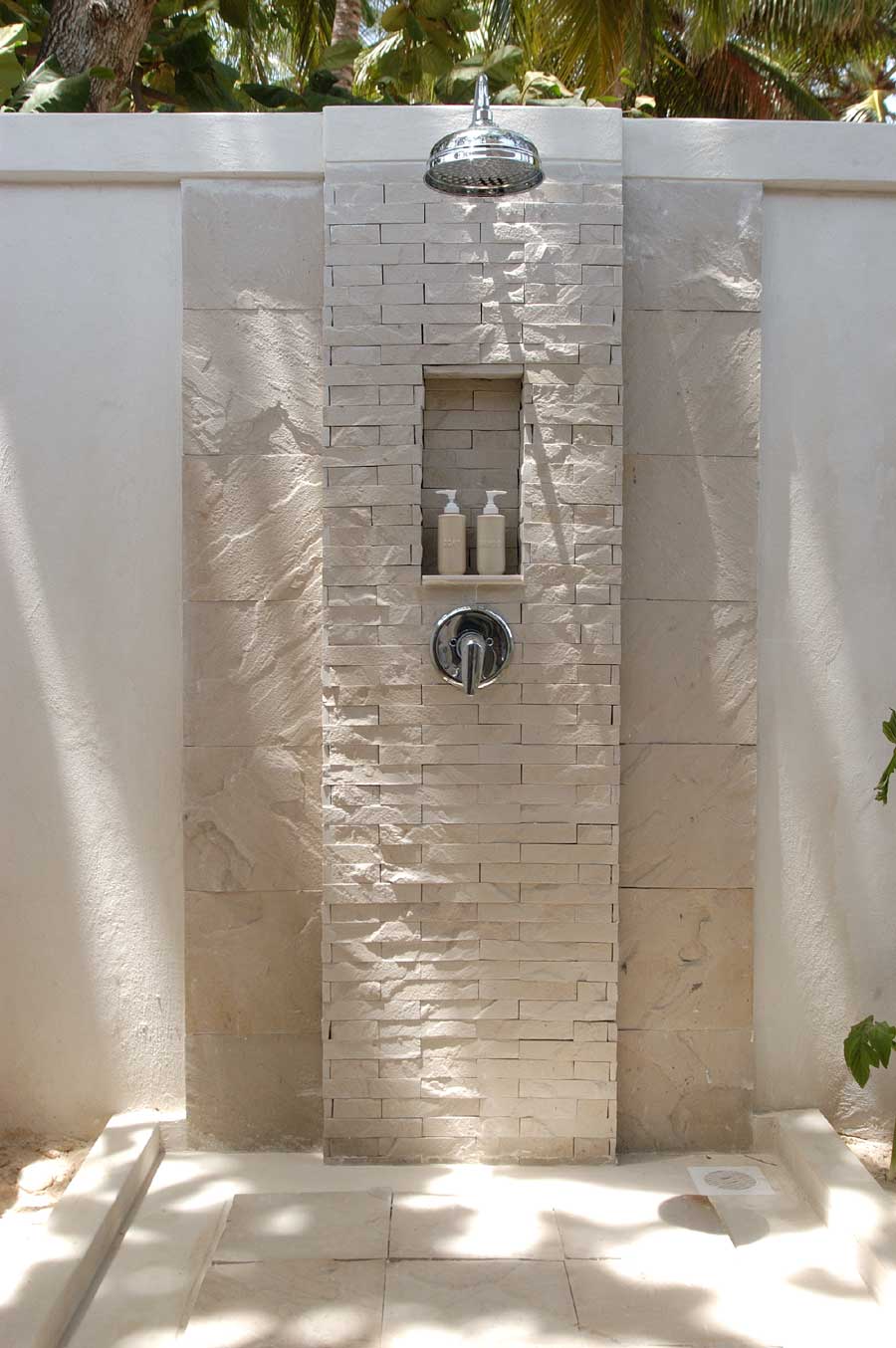 gartengestaltung mit weißer gartenwand und duschbereich mit naturstein