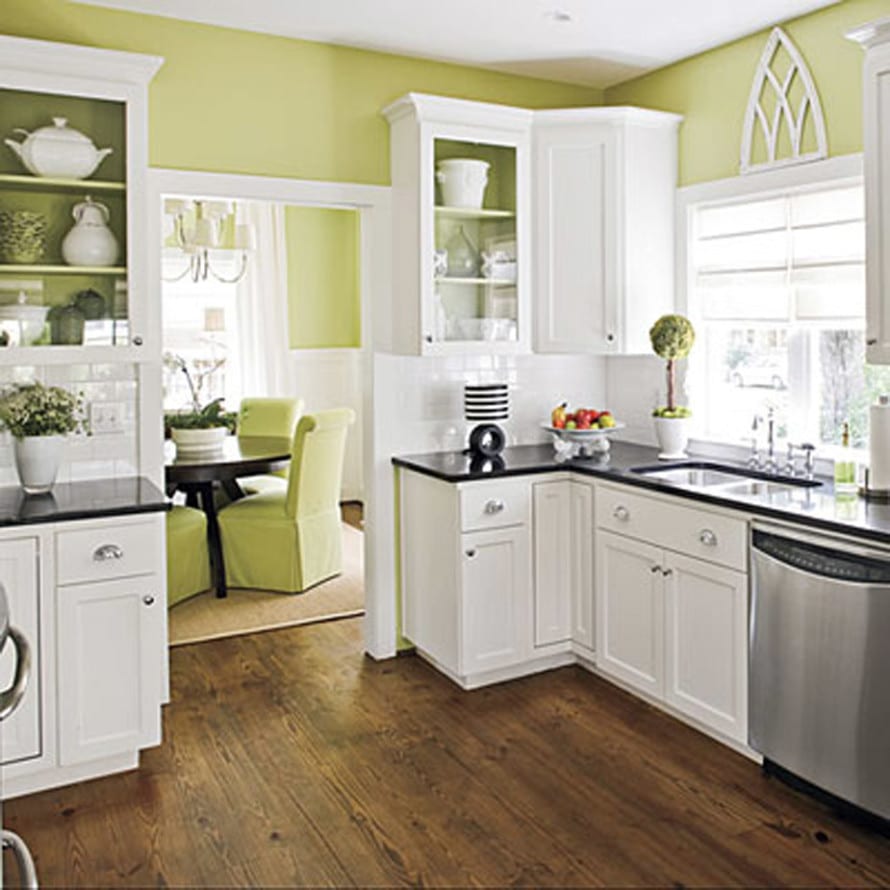 kleine küche mit weißen küchenschränken und grünen wänden
