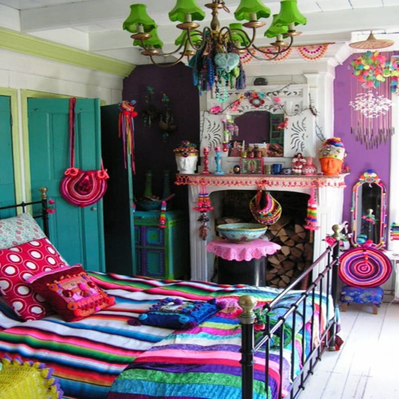 schlafzimmer mit blauer Tür und Wände in Violett-weißer Kamin-schwarzes Metallbettgestell und farbige Bettwäsche-kreative Dekenleuchte in grün