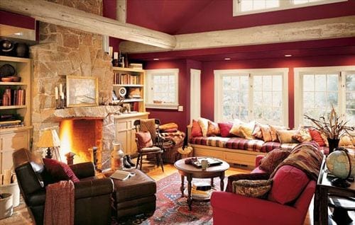 wohnzimmer farbgestaltung- wandfarbe dunkelrot- weiße fensterrahmen-kamit aus naturstein