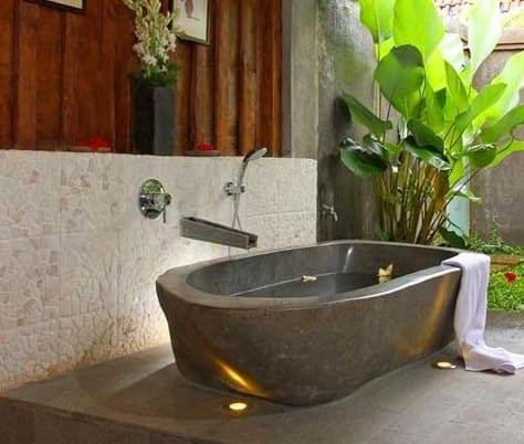 freistehende badewanne aus naturstein grau für offenes badezimmer im garten