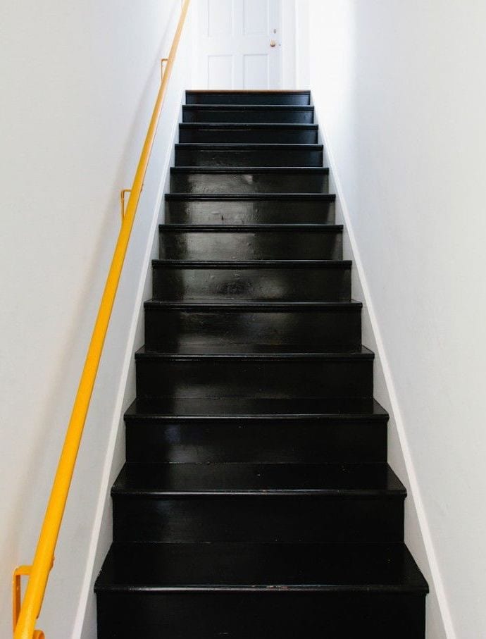 moderne treppe in schwarz mit gelbem wand-handlauf