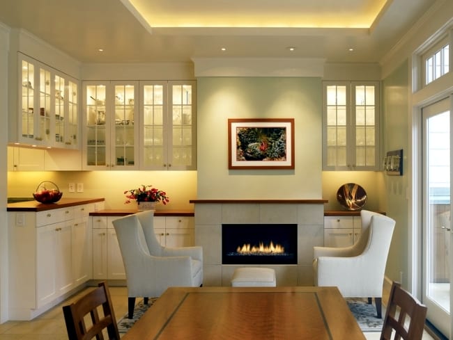 modernes wohnesszimmer mit kamin und esstisch massiv_wandfarbe hellgrün kombiniert mit weißen schränken