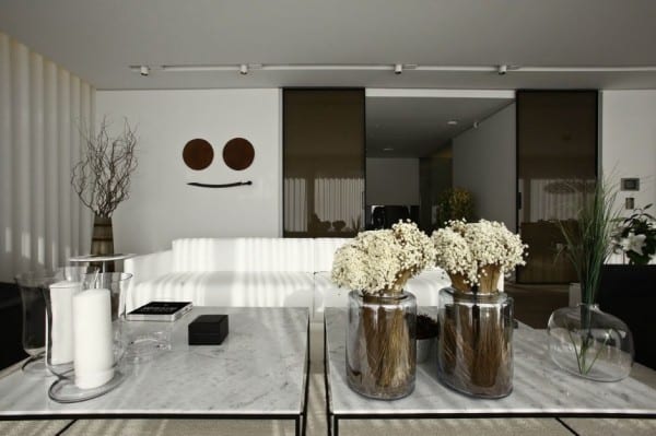 couchtisch deko idee mit kerzen und glasvasen mit blumen für luxus wohnzimmer schwarz-weiß