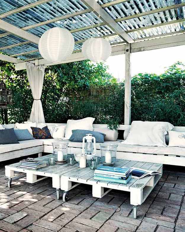 gartenterrasse mit Pergola Terrassenüberdachung in weiß mit weißen gardinen und Kugel-Pendellampen und Gartenmöbel aus paletten 