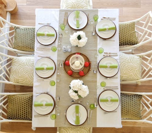 tisch eindecken in weiß und grün und esstischstühlen weiß aus holz mit grünen sitzkissen dekorieren