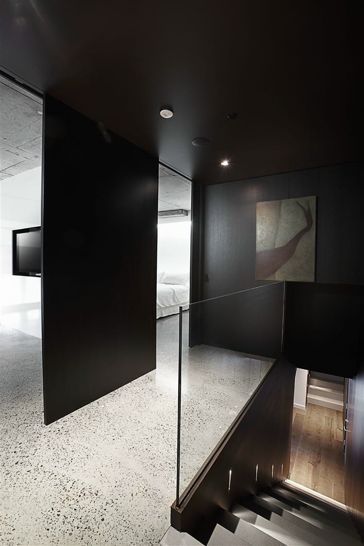 minimalistisches interior design mit schwarzen wänden und innentreppe holz mit glastreppengeländer