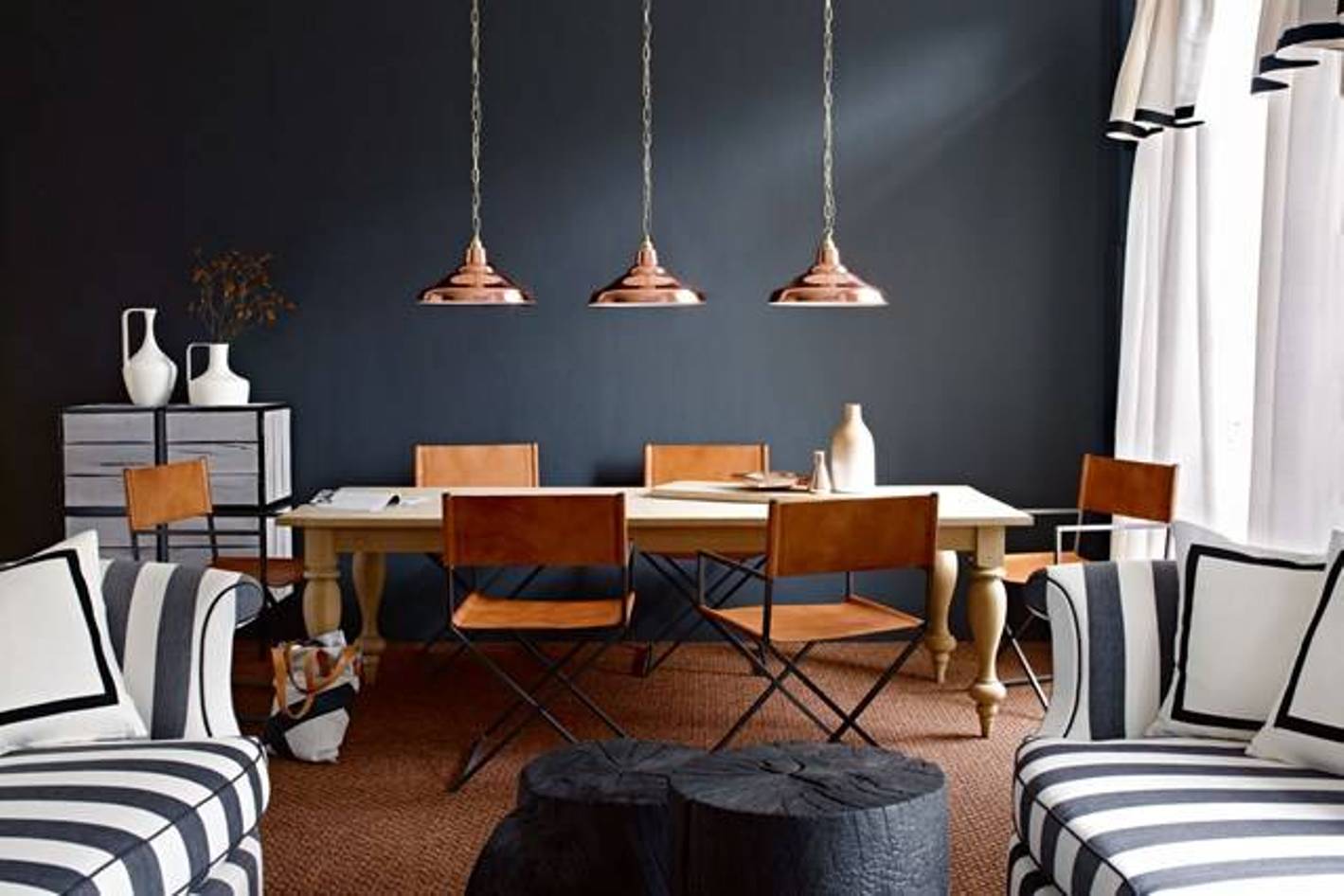wohnesszimmer modern einrichten mit holzesstisch massiv und klappstühlen_seats und sofas mit streifenmuster in schwarzweiß und coole couchtisch aus runden Holzklötzen