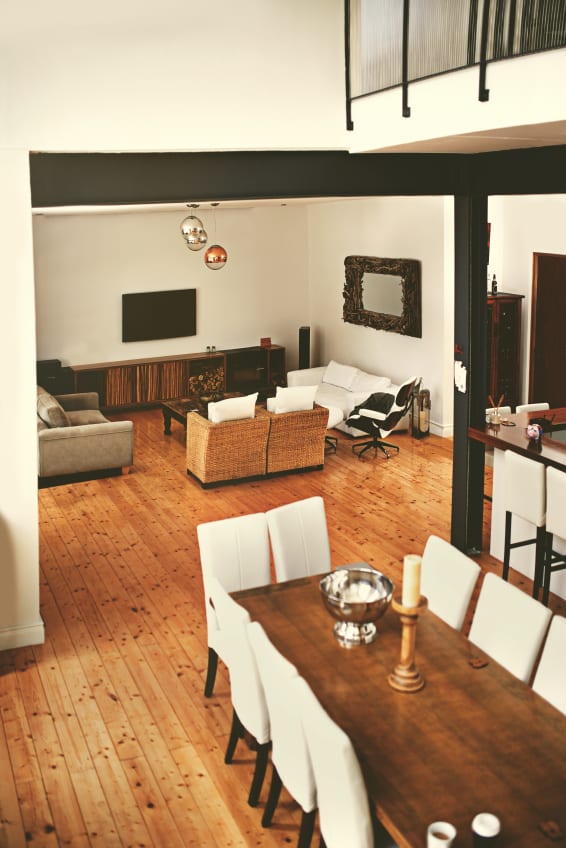 modernes wohn-esszimmer mit sichtbaren stahlträger schwarz und esstisch aus massivholz mit weißen esstischstühlen