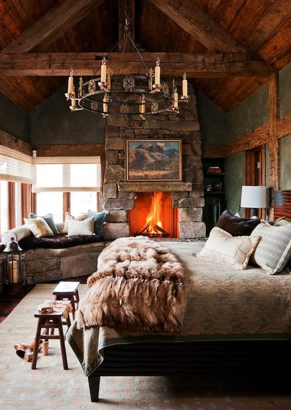 rustikale schlafzimmer mit kamin und fensterbank aus steinen, wandfarbe grün, holzhocker,vintage-kronenleuchter 